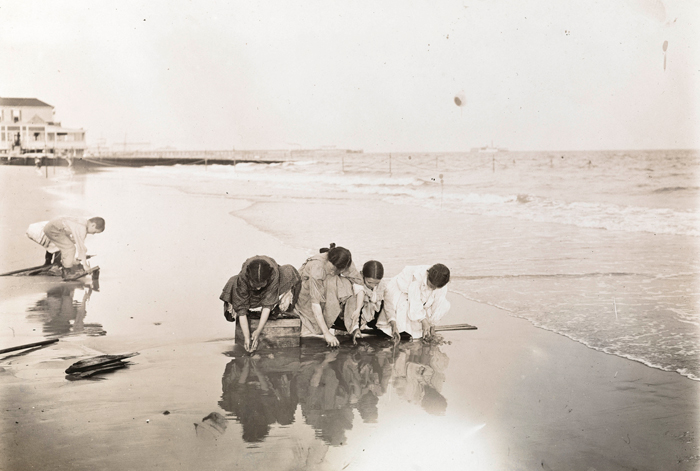 Uma foto do museu por Jacob A. Riis de crianças brincando pela água, tirada em 1895.