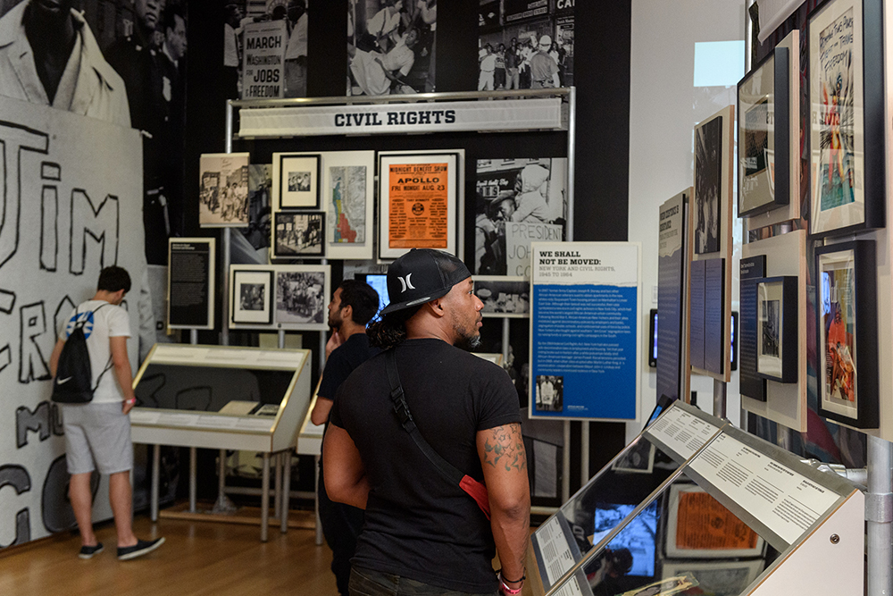 뉴욕시 박물관의 활동가 뉴욕 전시회를 방문한 한 방문자가 도시의 사회 변화 역사에 대한 유물을 살펴 봅니다.