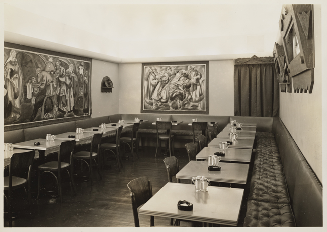 俄国茶室的内部有餐桌和艺术品的在墙壁上。