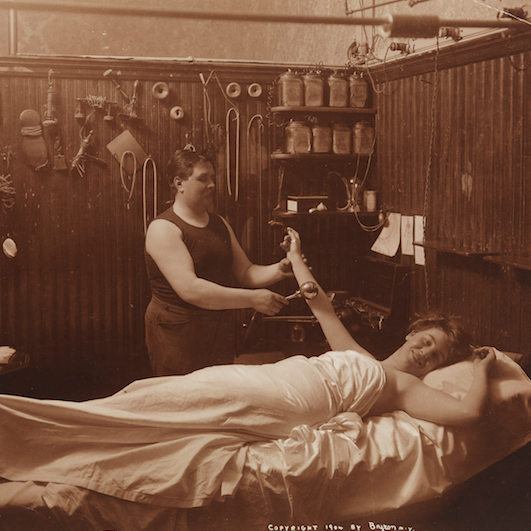 Uma mulher em repouso, recebendo algum tipo de massagem terapêutica em um banho turco.