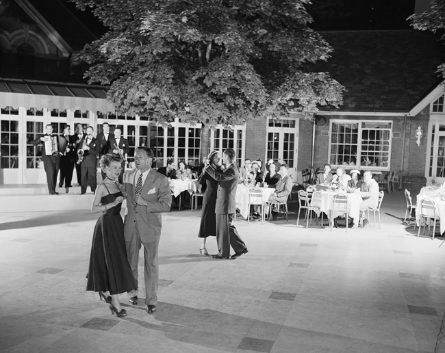 夫妇在绿色的小酒馆的露台上晚上跳舞。