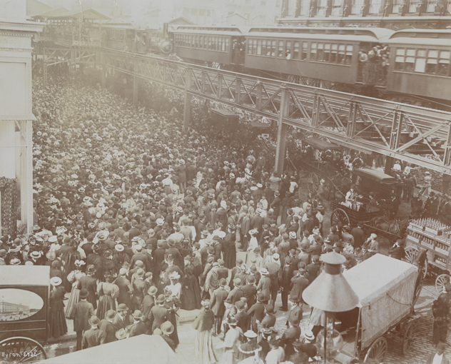 Crowds of people outside Siegel Cooper department store on its opening day in 1896, with the Sixth Avenue elevated train above.