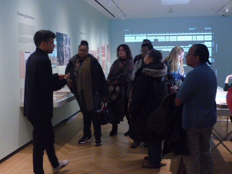 Um grupo de professores explora a exposição do museu "Quem Somos: Visualizando Nova York pelos Números"