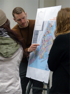 Os participantes discutem um mapa usando diferentes alfinetes e miçangas de cores para mostrar seu bairro, duração do trajeto e local do local de trabalho para analisar os padrões de deslocamento.