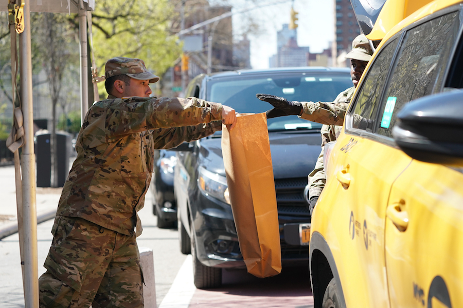 [Des membres de la Garde nationale de l'armée américaine distribuent de la nourriture à Harlem]