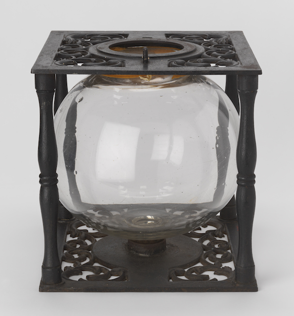 Urne avec globe en verre dans un cadre en fonte.