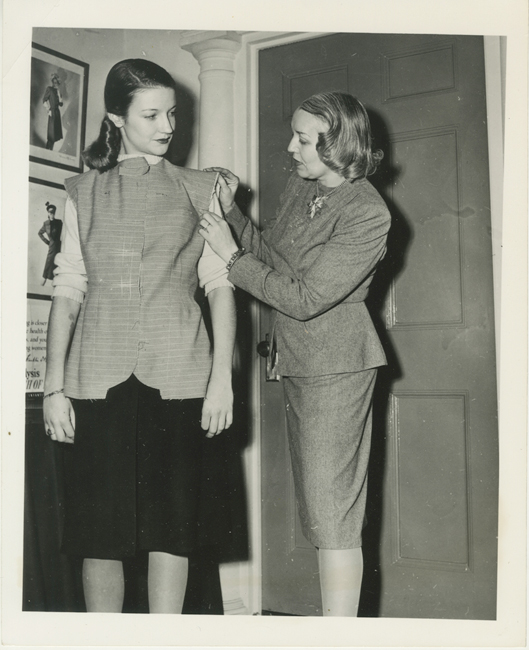 Une photo de Vera Maxwell ajustant un modèle pour "Un hommage à Vera Maxwell" du Musée de la ville de New en 1942.