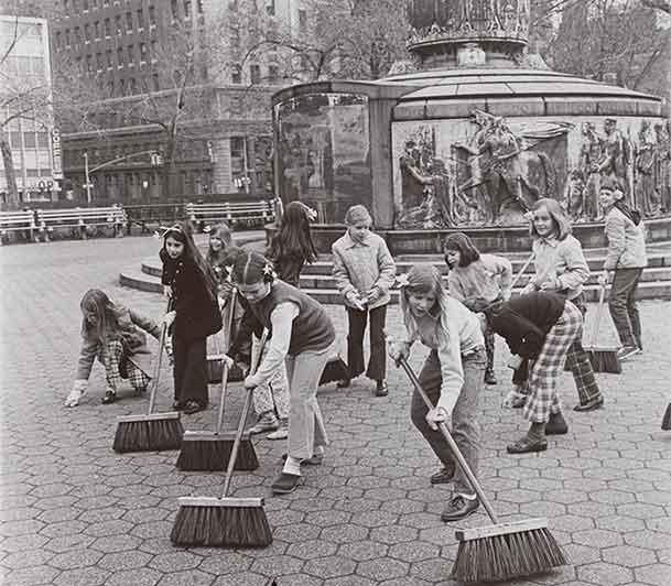 アースデイにニューヨークの歩道を掃除している女の子のグループの白黒写真。