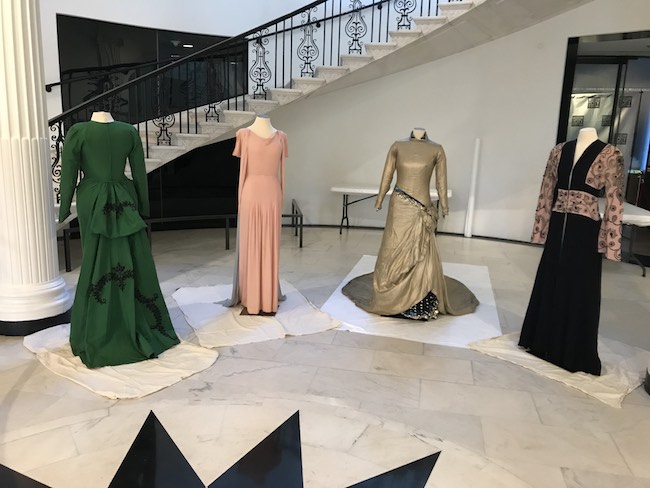 박물관의 주요 계단 앞에 배치 된 마네킹을 입은 다양한 색상과 스타일의 Marian Anderson 소유의 드레스 XNUMX 개.