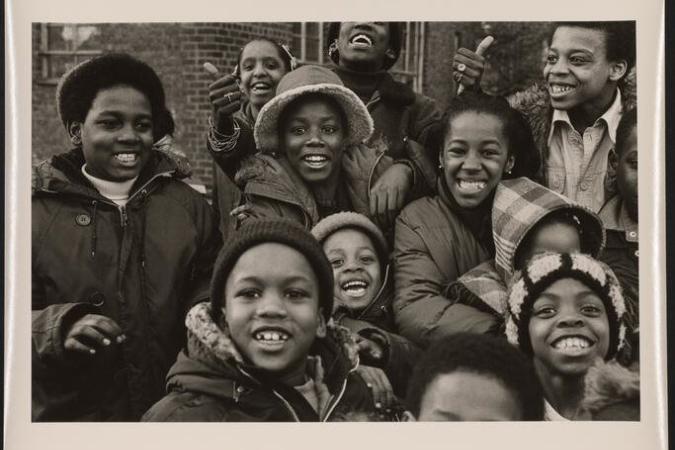 Um grupo de crianças se reúne e sorri para a câmera.