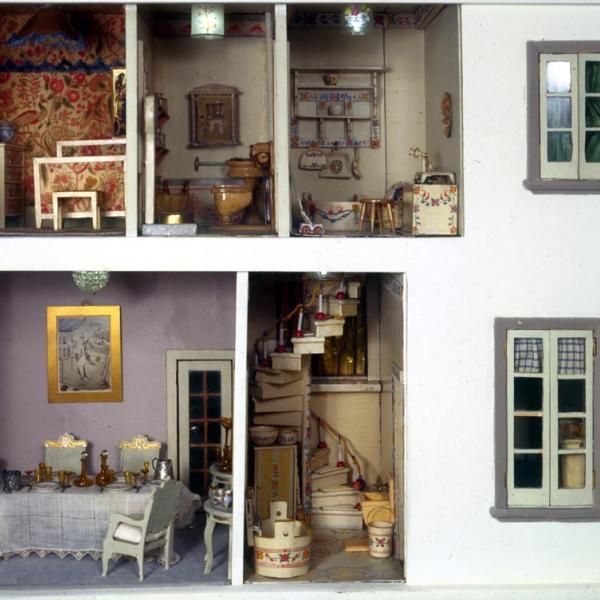 Vista de duas janelas, escadas e sala de jantar mobiliada, banheiro e quarto na casa de bonecas Stettheimer