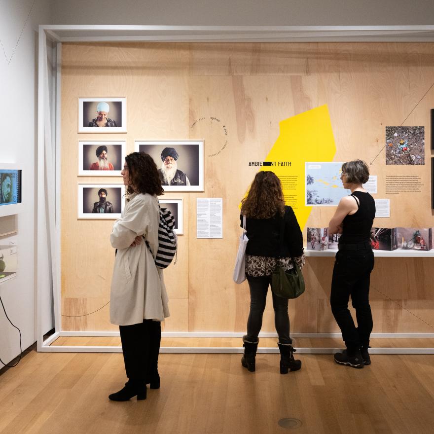 As pessoas visualizam o conteúdo da exposição da galeria.