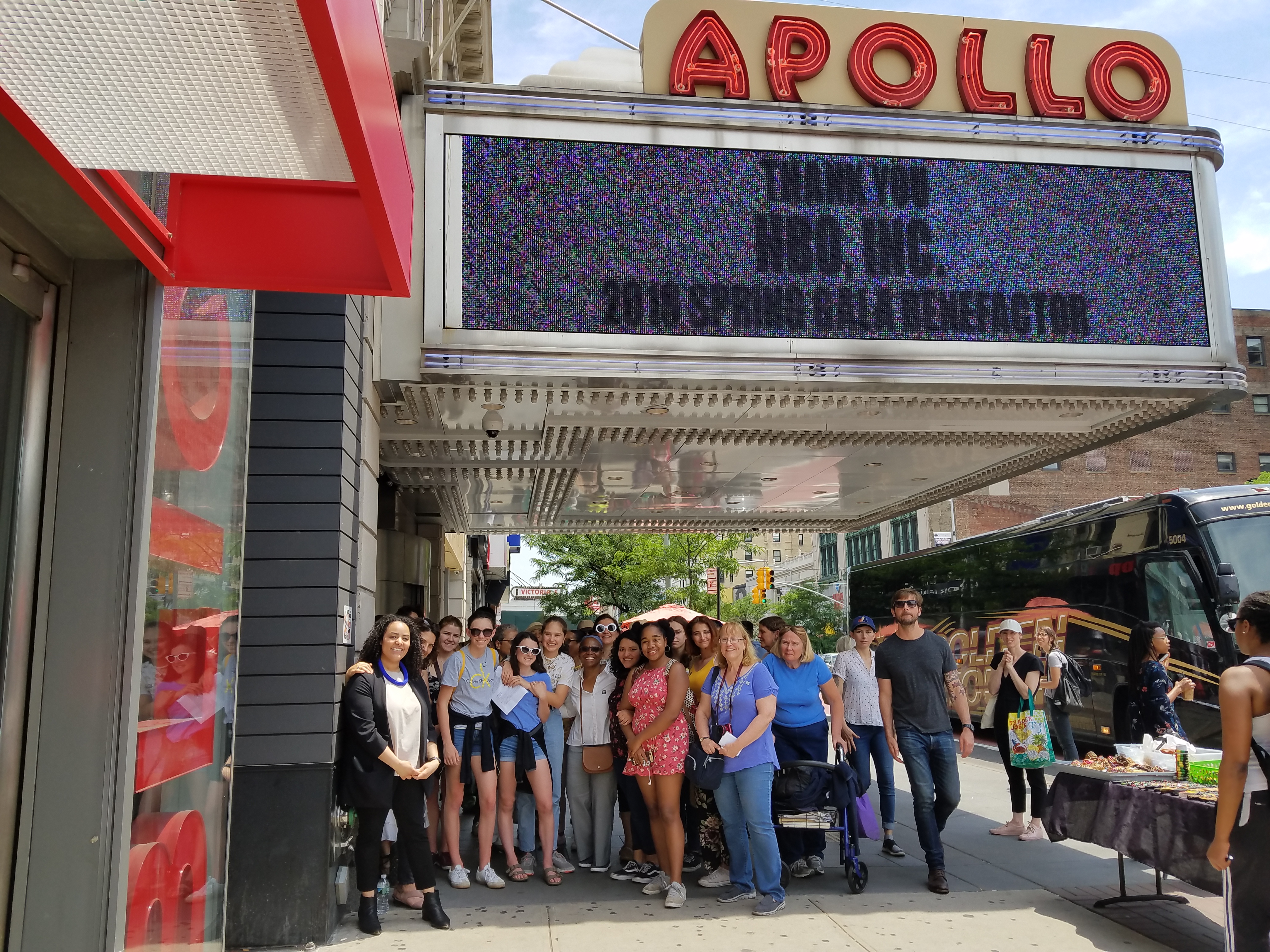 Un grupo de turistas de pie bajo la marquesina del Teatro Apollo.