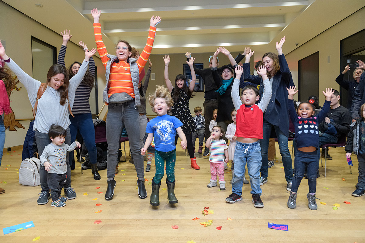 Un groupe d'adultes et d'enfants saute.