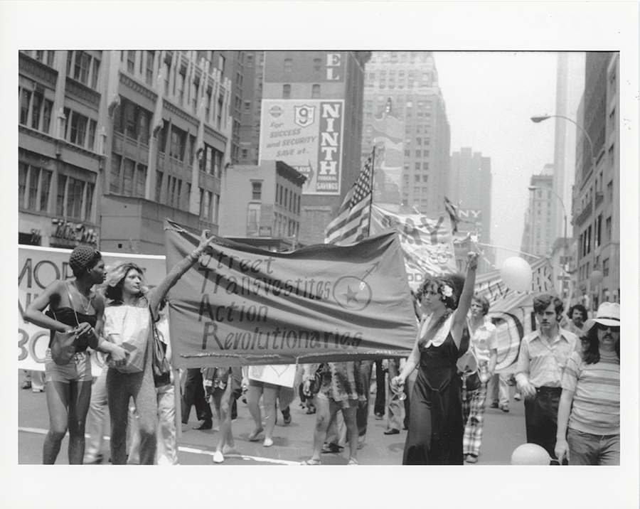 Membros dos Revolucionários da Ação de Travestis de Rua erguem a faixa do grupo enquanto se juntam à Marcha do Dia da Libertação da Rua Christopher em 1973.