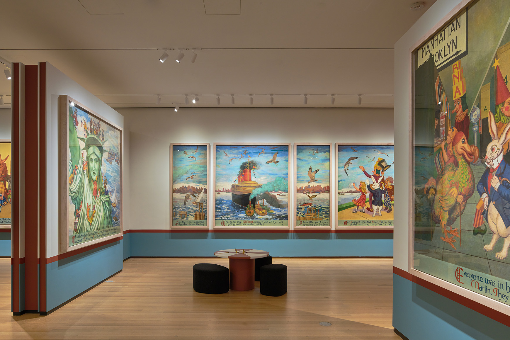 Large mural panels showing Alice and other characters exploring New York City, with red and white tables in the middle of the gallery.