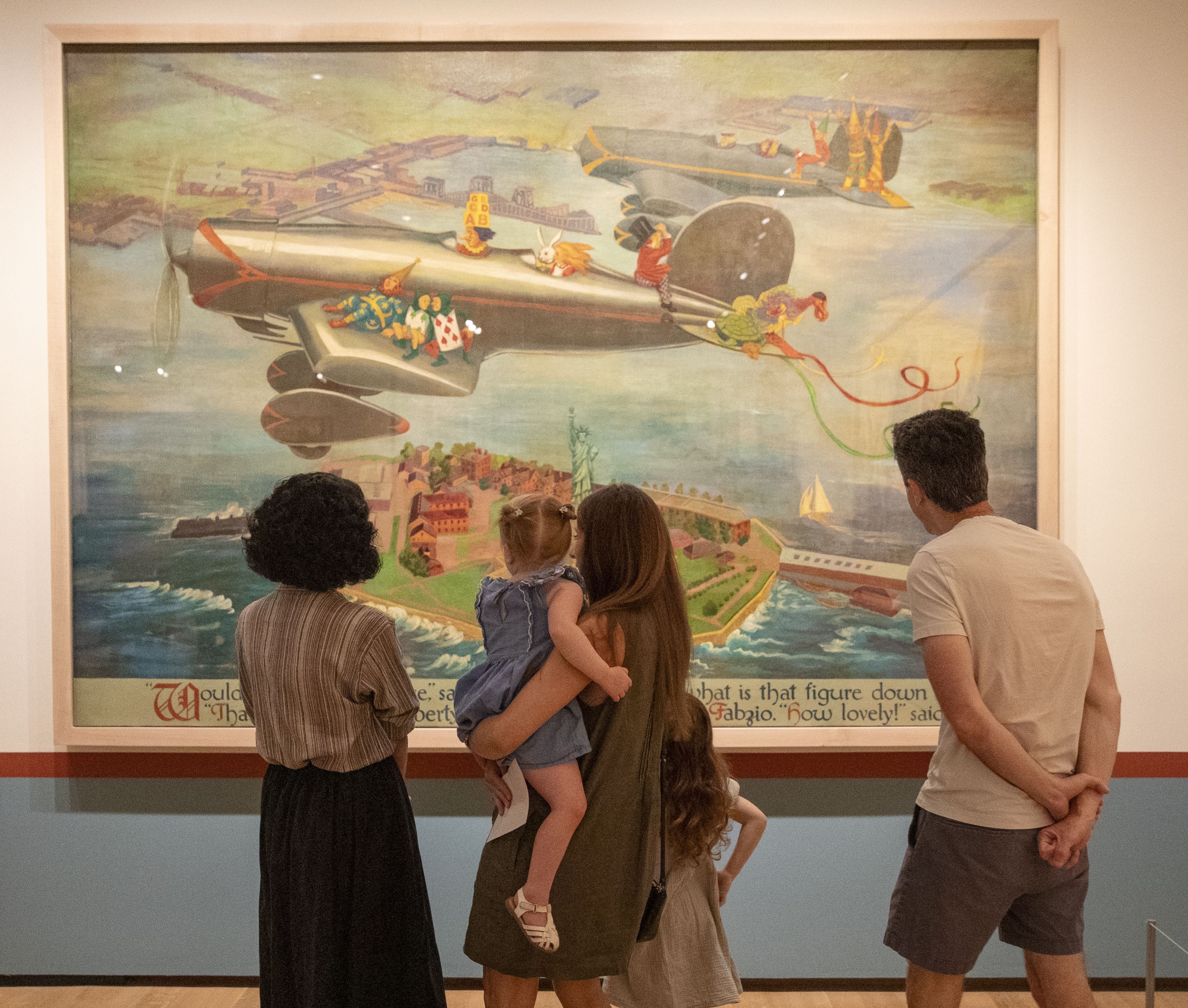 Group of 5 gathers to view Wonderland Mural Pannel; 3 adults 2 children