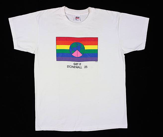 Photograph of a white t-shirt with a PRIDE flag. Beneath illustration of flag is text that reads “Get it Stonewall 25”
