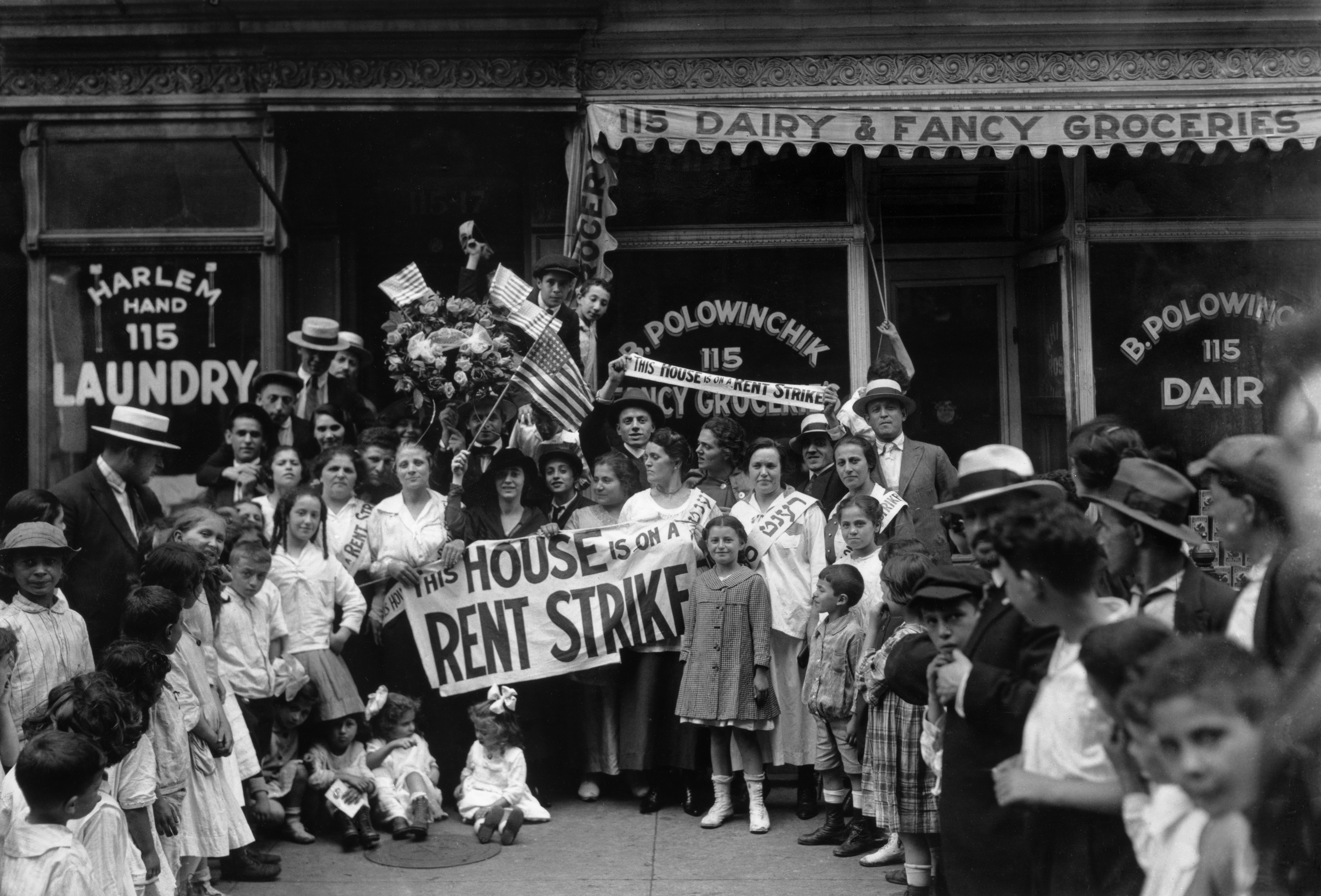 A group of men, women, and children during a rent strike in Harlem. 
