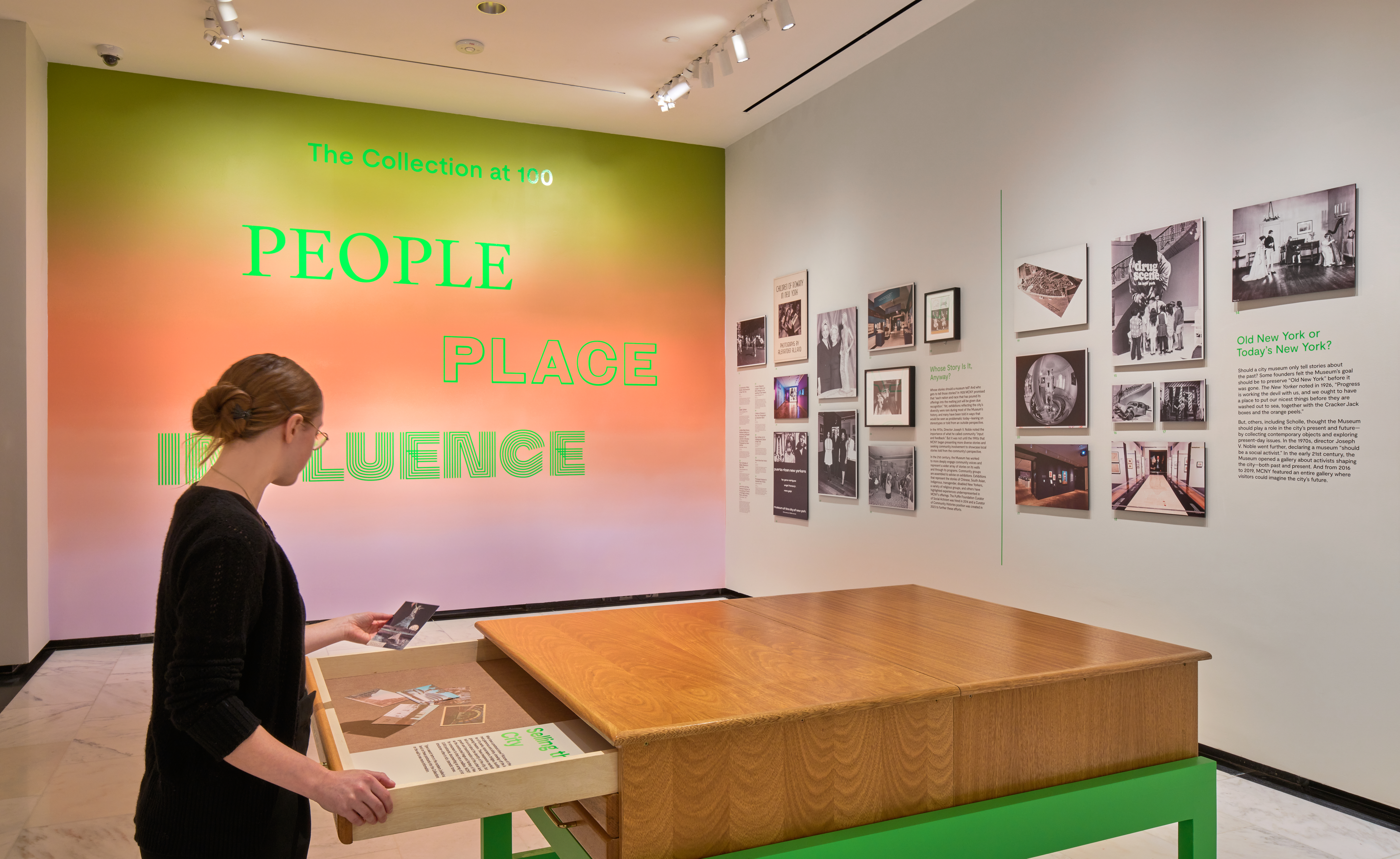 A woman opens a drawer in a gallery. 