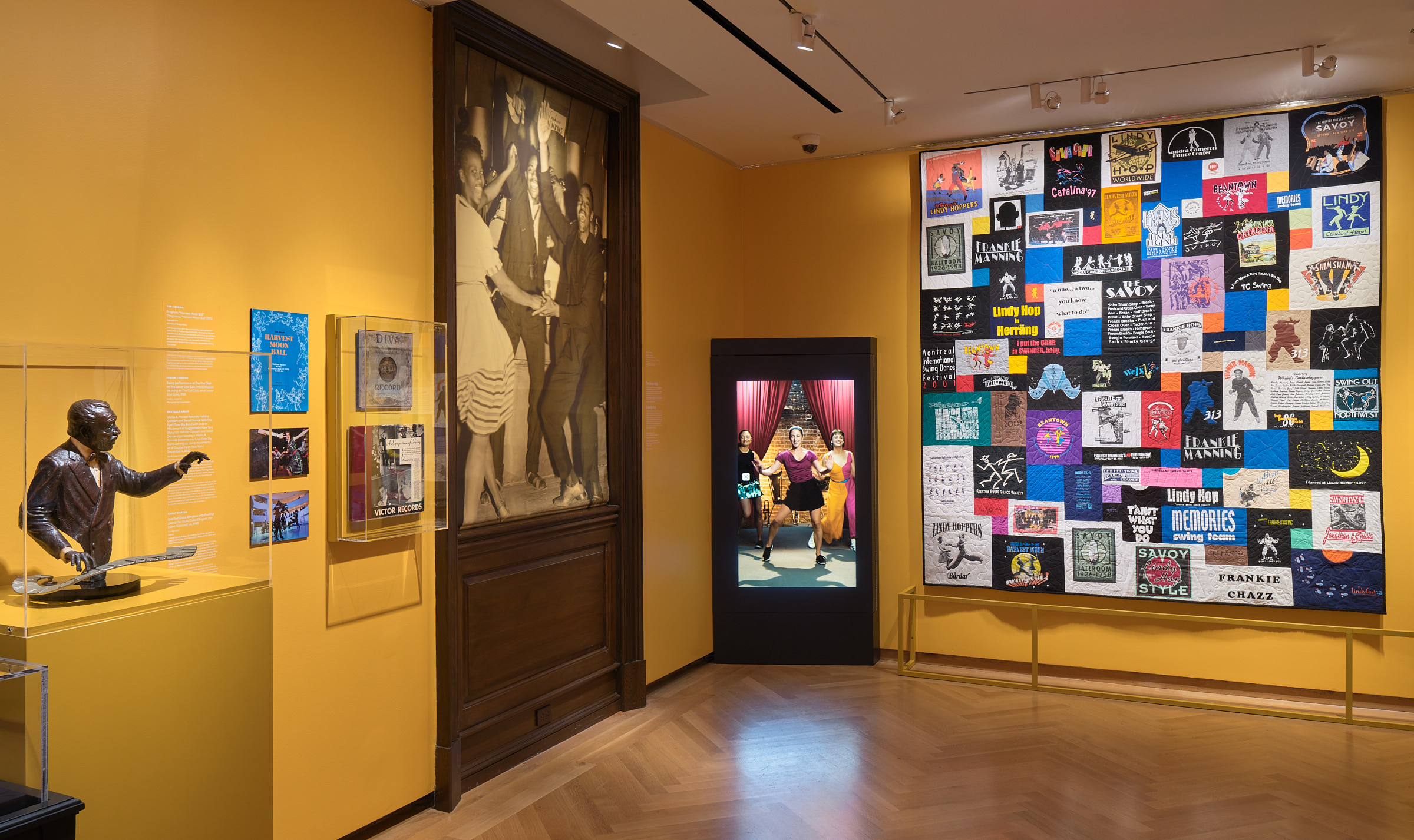 Museum exhibition with yellow walls and people dancing