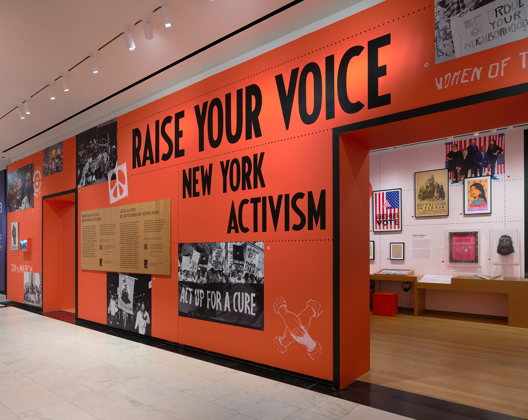 A gallery wall painted bright red and reading Raise Your Voice: New York Activism