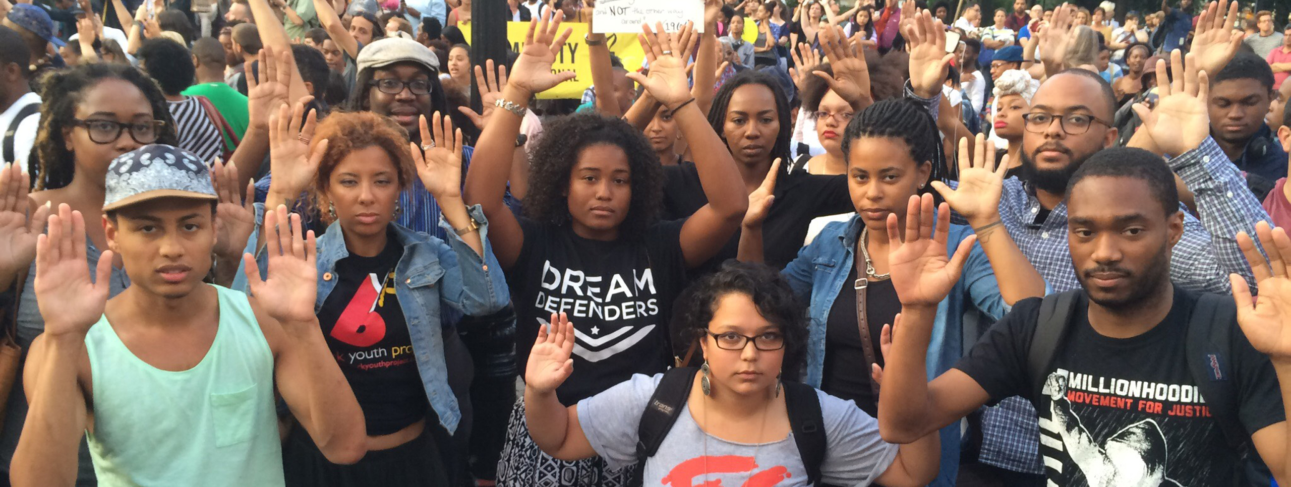 Black Lives Matter protesters with their hands in the air in a sign of surrender and the “hands up don’t shoot” slogan