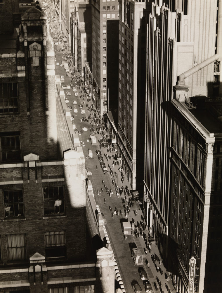 Vue d'une rue de New York entourée des deux côtés par de hauts bâtiments, créant un «canyon» avec la rue
