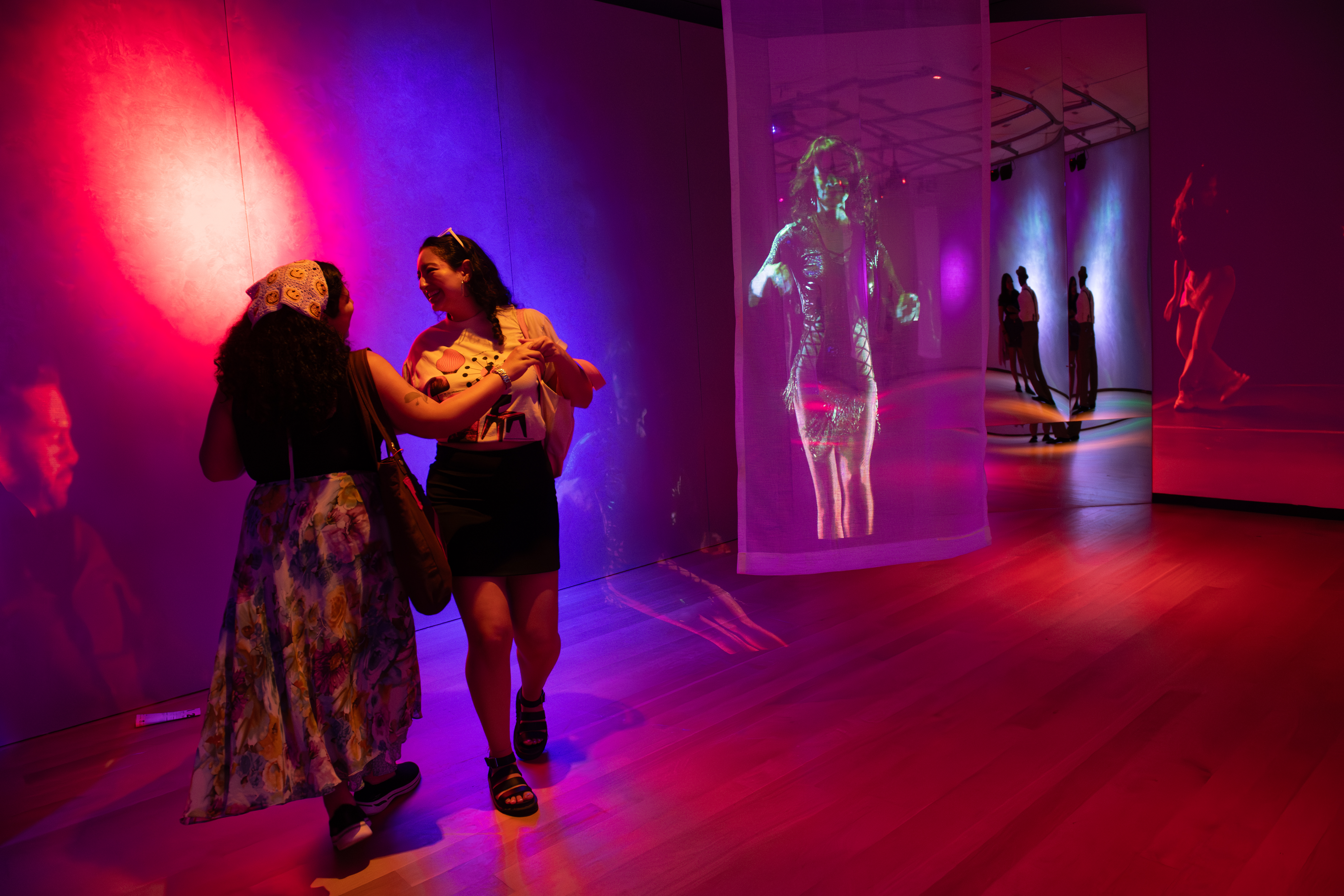 Two women dancing together in the Museum of the City of New York