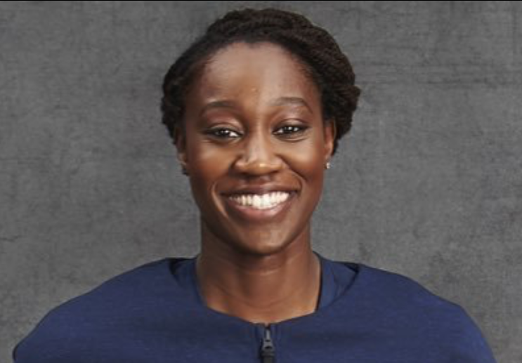 Tina Charles head shot - gray background with blue shirt
