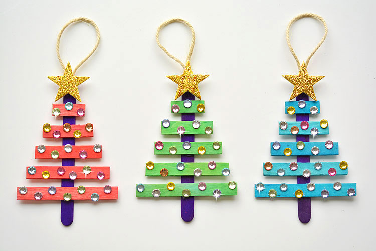 Red, green, and blue ornaments made from popsicle sticks and decorated with gemstones.
