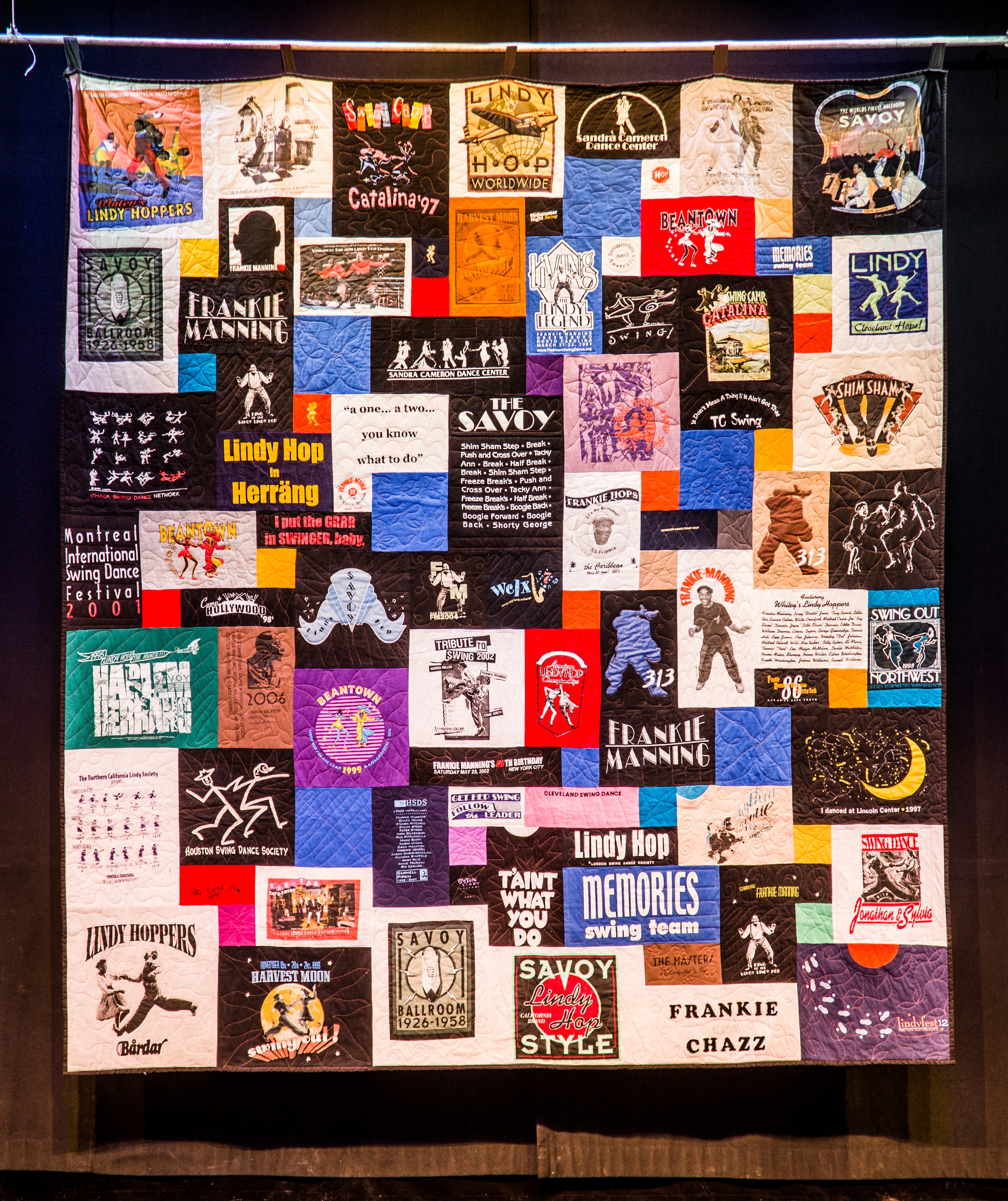 An image of a quilt with multiple colorful rectangular patches with people dancing and words like "Frankie Manning" and "Savoy"
