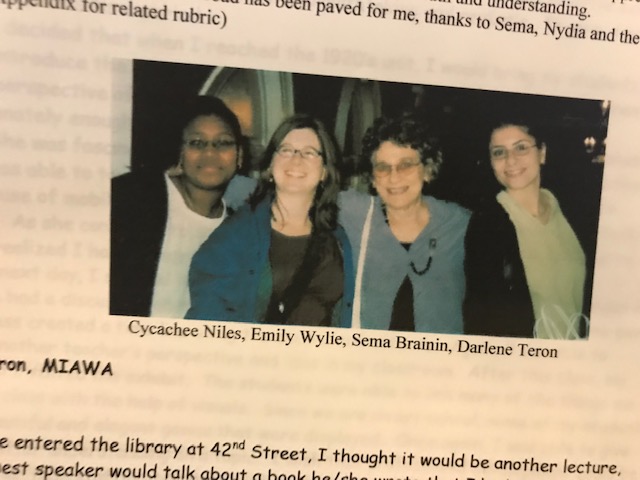 Newspaper clipping showing a color image of four women standing together.