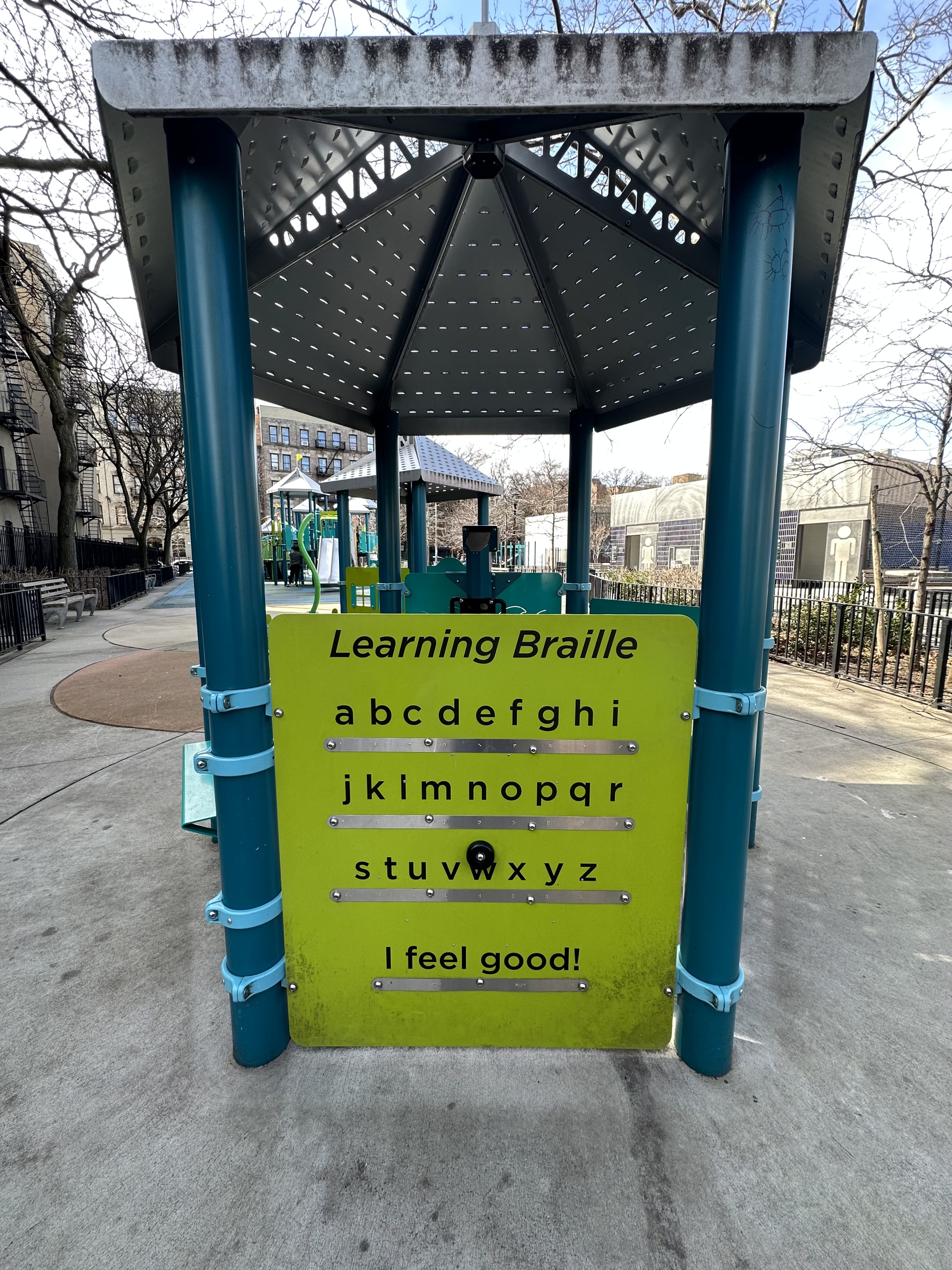 Fotografia a cores de um painel Braille num parque infantil.