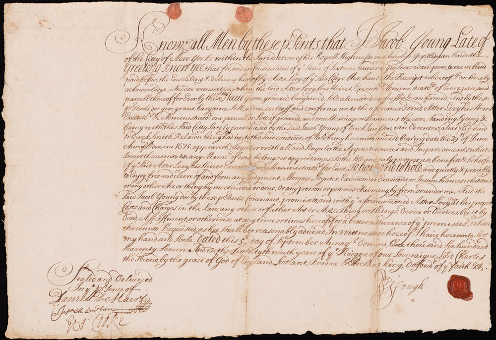 An old piece of paper with elaborate script writing and a wax seal in the bottom right corner