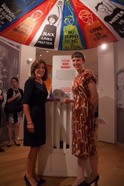 Fotografia do governador Hochul (à esquerda) e da curadora Sarah Seidman (à direita) na abertura da exposição Além do sufrágio.