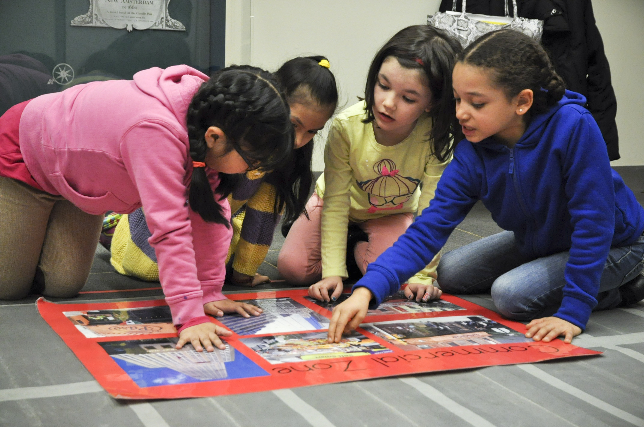 Cuatro niños miran un mapa.