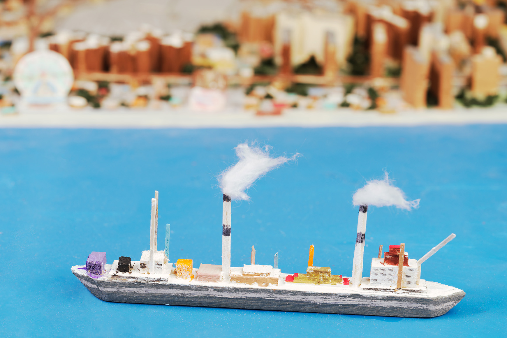 A handmade wooden boat on a scale model of New York City
