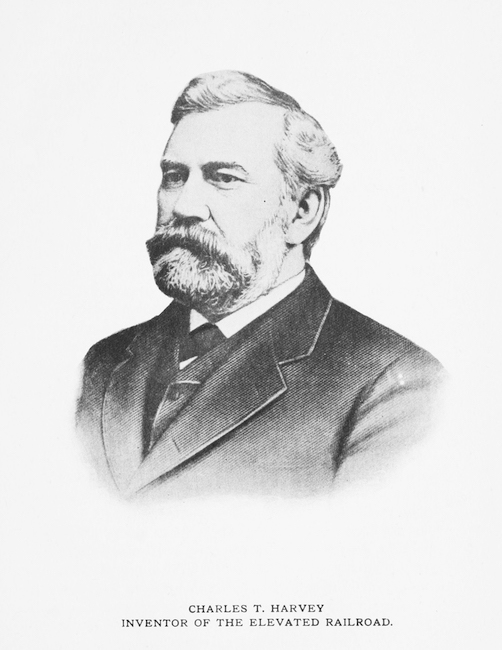 Black and white portrait of a man with a beard and mustache in a suit and tie.