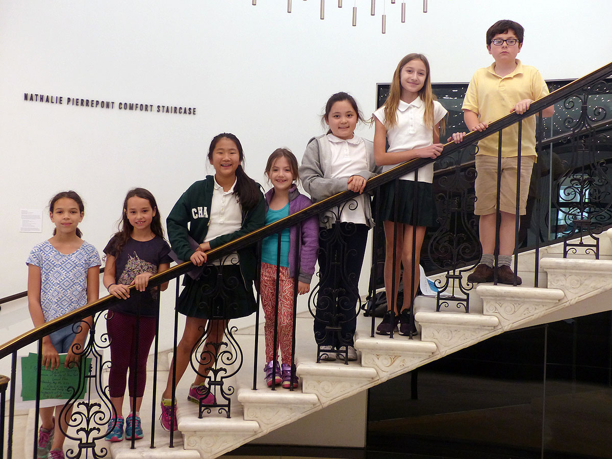 어린 아이들 그룹이 뉴욕시 박물관의 계단에 모입니다.