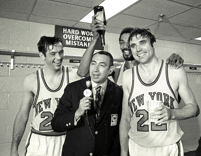Dave DeBusschere and Bill Bradley pour champagne on ABC announcer Howard Cosell.