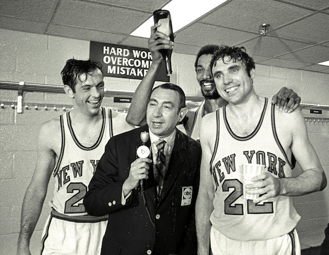 Dave DeBusschere et Bill Bradley versent du champagne sur l'annonceur ABC Howard Cosell.