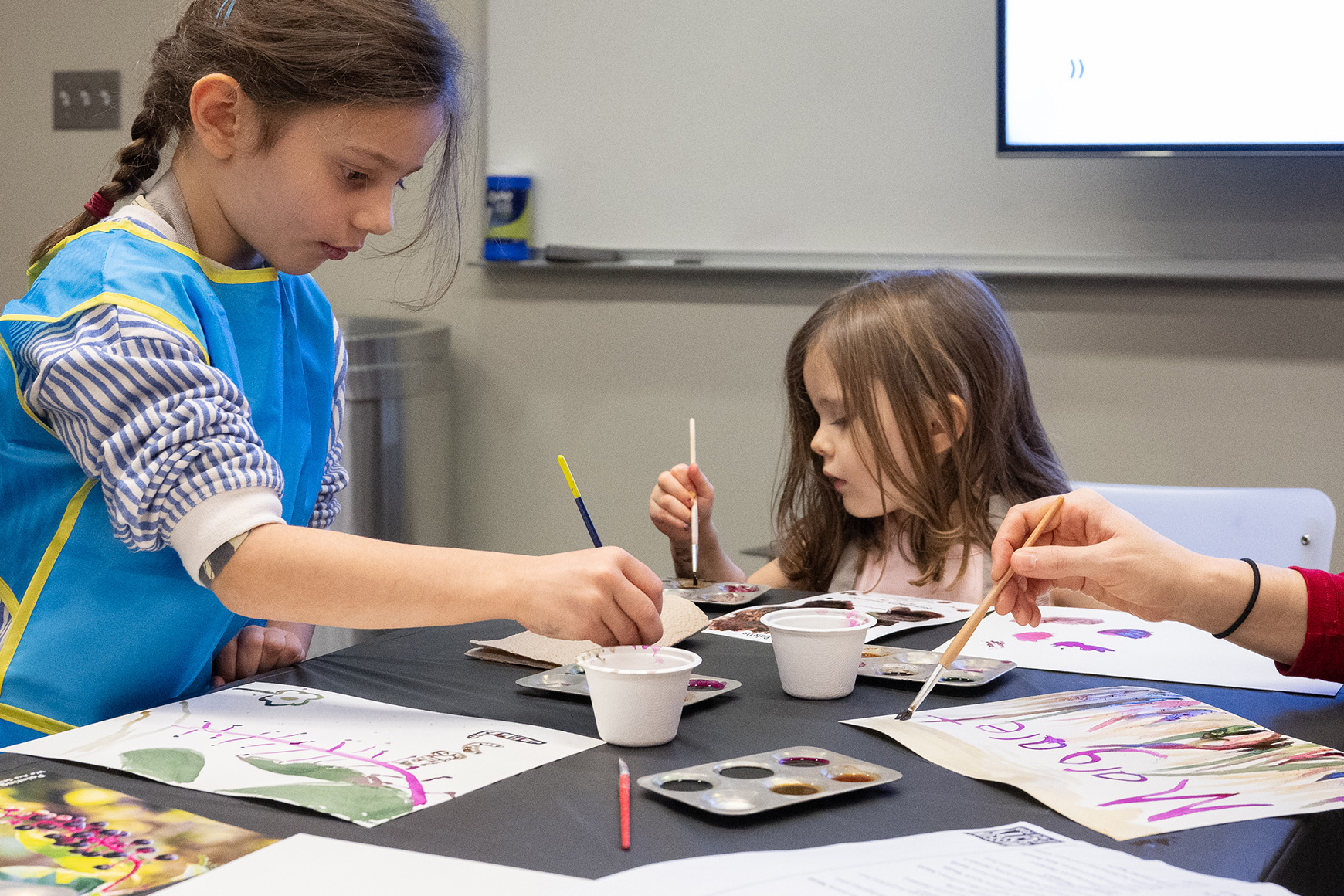 Two children creating an artwork with watercolor paint.