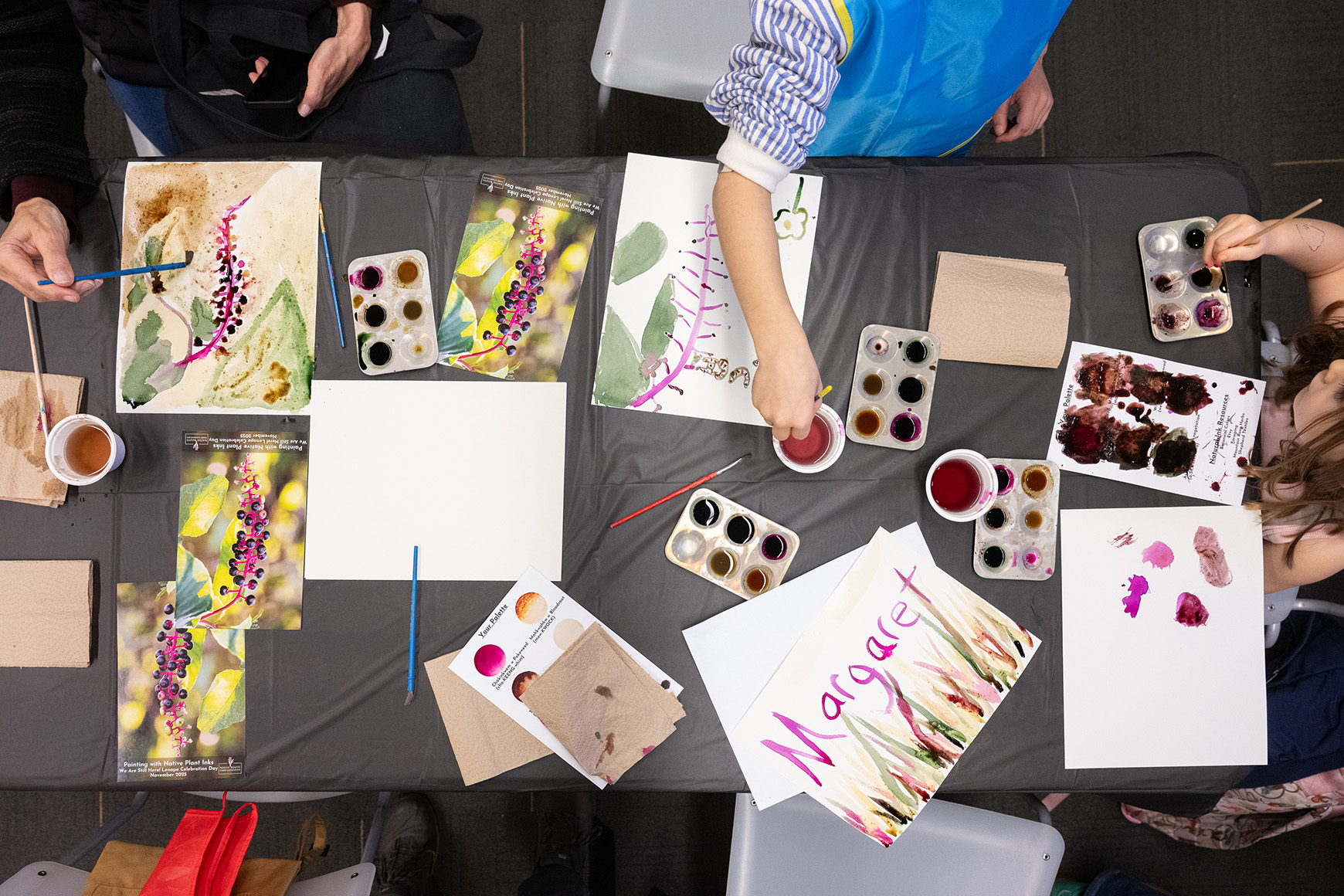 Several children creating an artwork with watercolor paint.