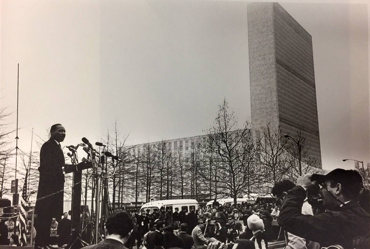De uma plataforma elevada, o Rev. Martin Luther King Jr. se dirige a uma multidão reunida de jornalistas na cidade de Nova York