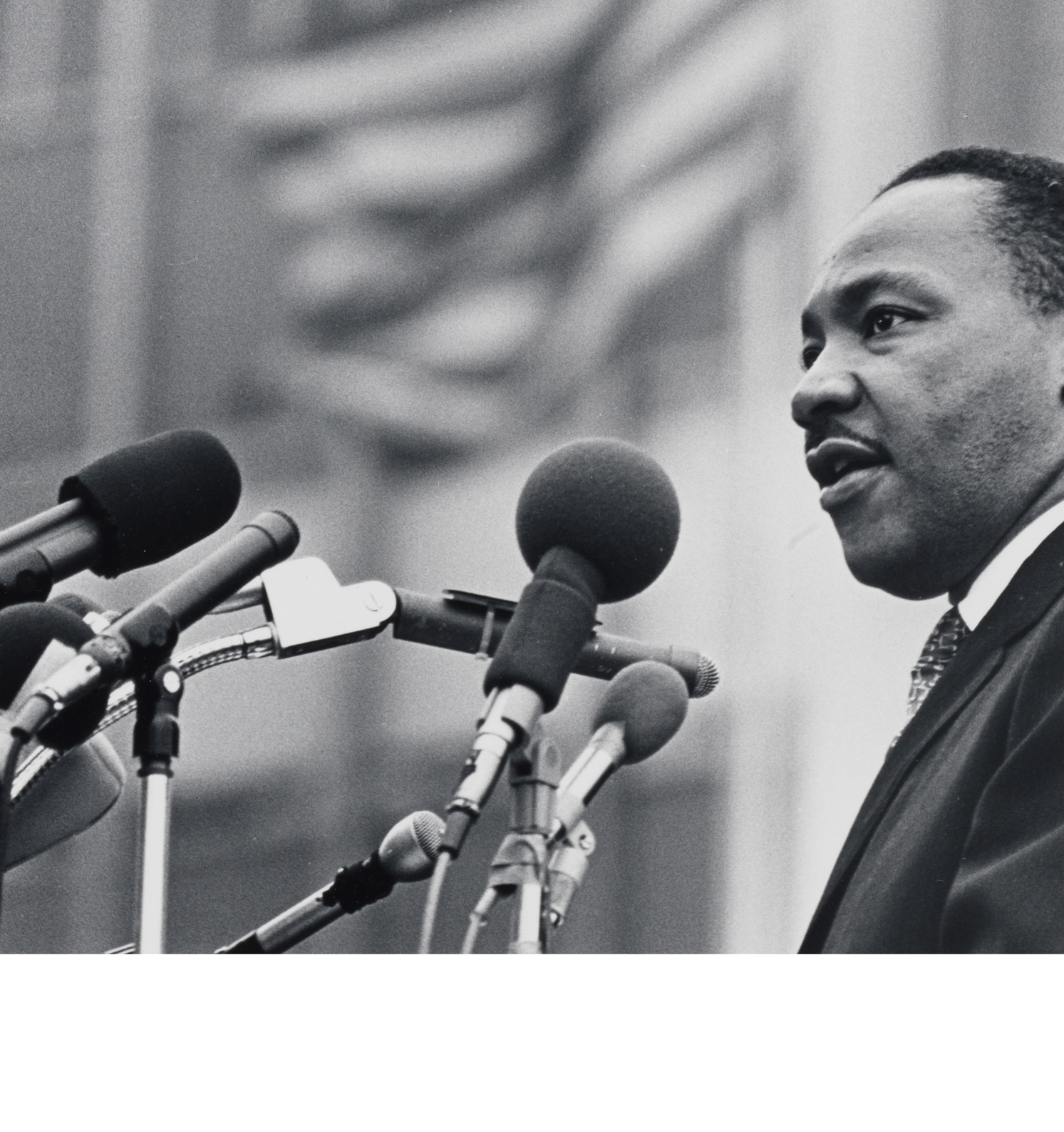 Image du Dr Martin Luther King Jr. parlant dans plusieurs microphones.