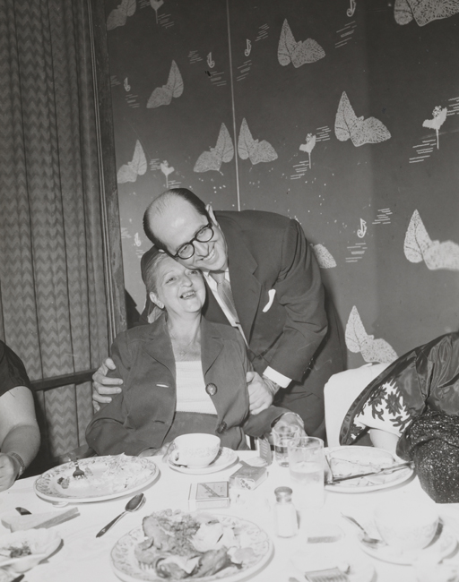 一个男人和女人在吃饭的桌子上拥抱。