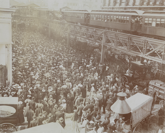 Multitudes de personas fuera de los grandes almacenes Siegel Cooper en su día inaugural en 1896, con el tren elevado de la Sexta Avenida arriba.