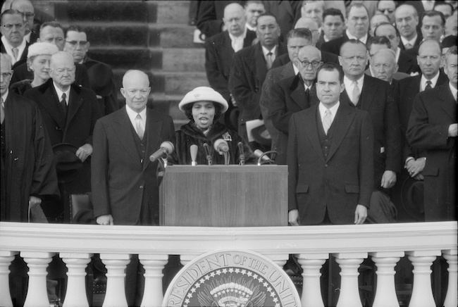 Photograph shows singer Marian Anderson performing at the Eisenhower Inauguration, as President Eisenhower and Vice President Richard Nixon stand behind her.