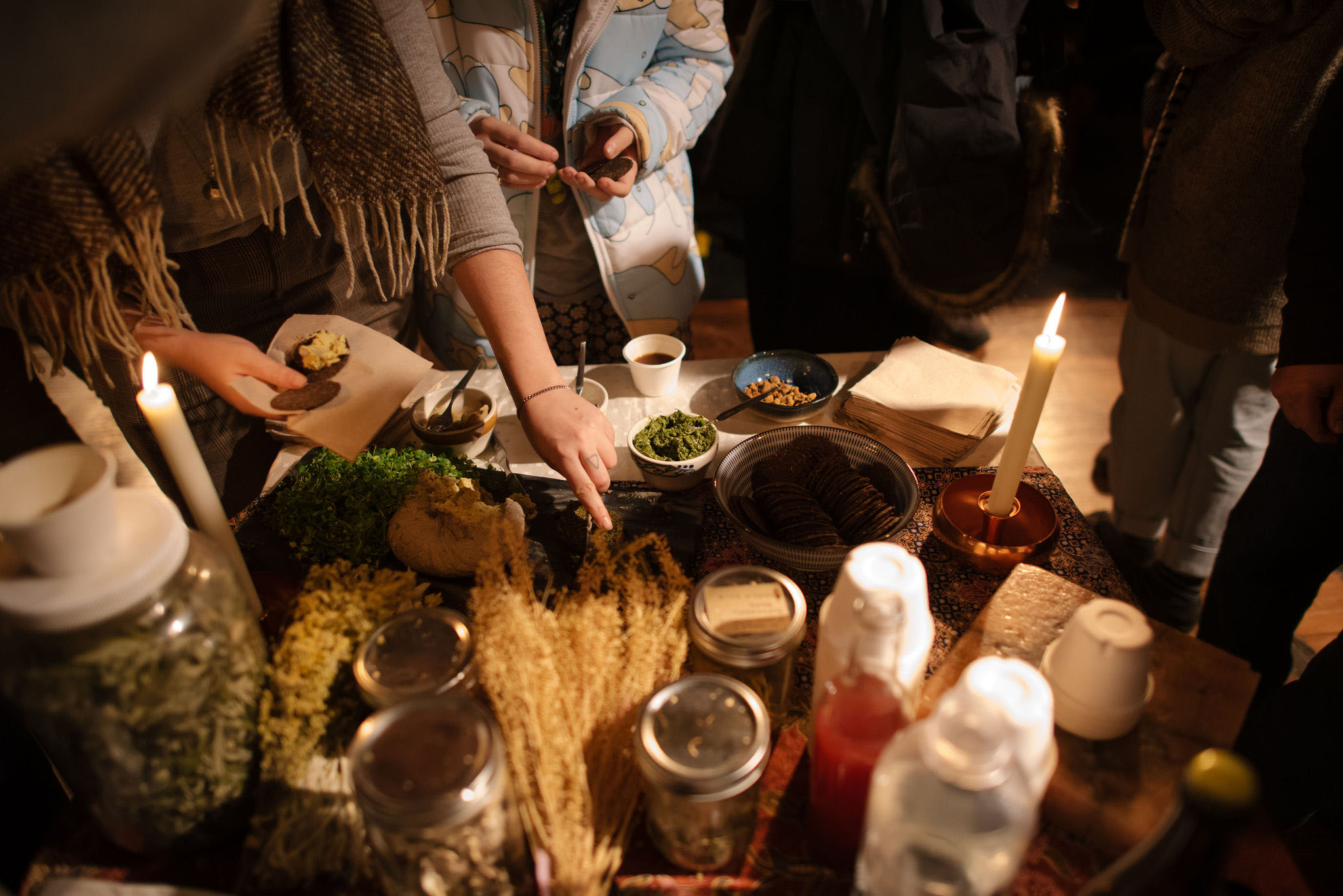 Imagem de ingredientes alimentares em uma mesa com pessoas reunidas ao redor